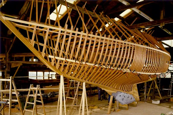 Holzskelett eines Schiffsrumpfes während des Bootsbaus in einer Werft.