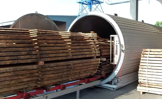 Blockware auf einem Schienenwagen vor der geöffneten Vakuum Trockenkammer bei WOB Timber.