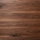 Großaufnahme der edlen, dunklen Holzmaserung von American Black Walnut mit sichtbarer Struktur und Wirbeln.