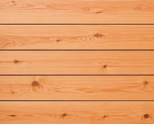 Horizontal liegende Bretter aus europäischer Douglasie mit warmer Holzfärbung und natürlicher Maserung.