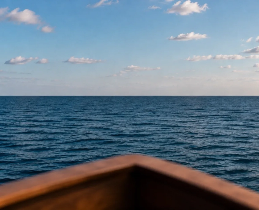 Holz für Bootsbau und Yachtausbau Unscharfer Holzbug eines Bootes mit Blick auf das offene, blaue Meer unter leicht bewölktem Himmel.