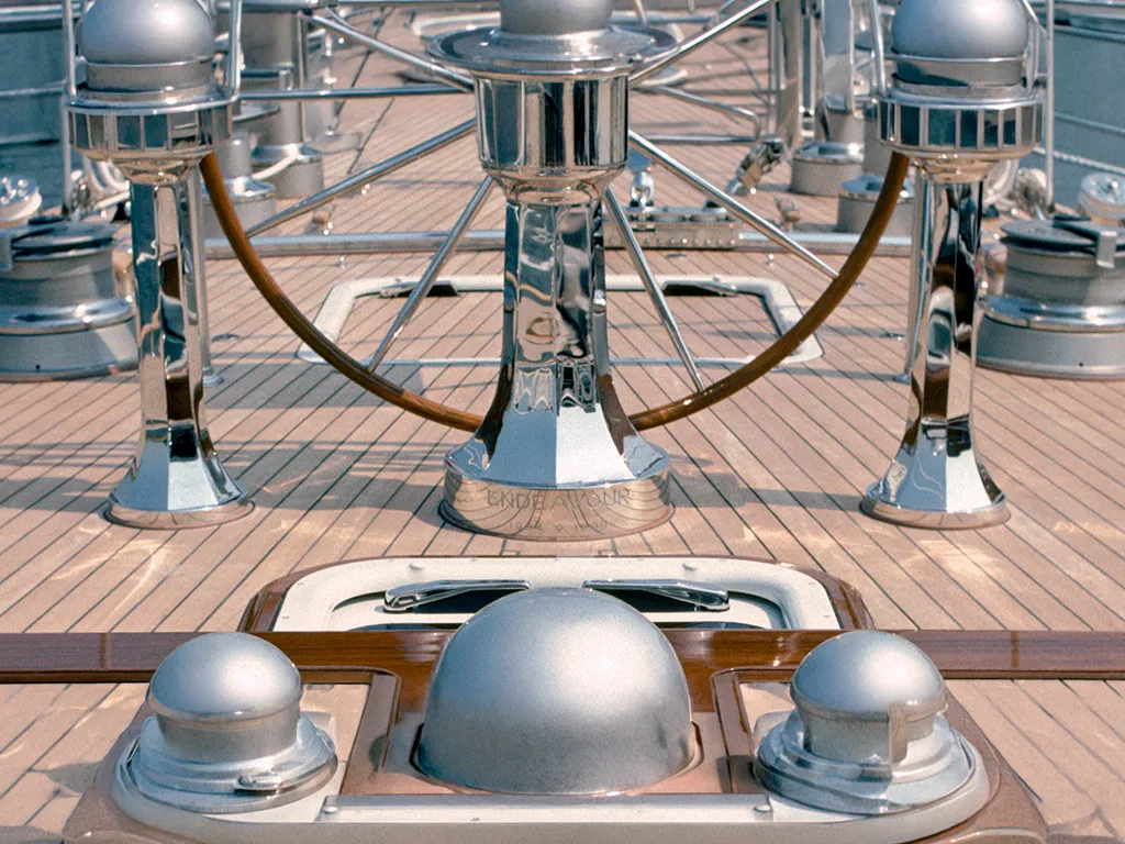 Teak Deck Bootbau Yachtbau Klassisches Teakdeck einer Segelyacht mit Steuerrad und glänzenden Chrom-Beschlägen.